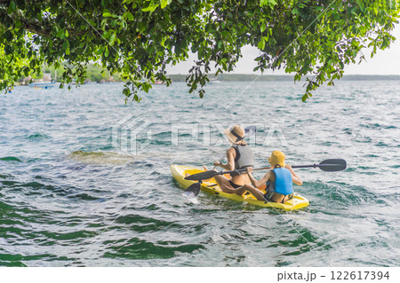 Mother and son tourists kayaking on Bacalar Lake in Mexico. Adventure tourism in Quintana Roo, outdoor exploration, and water activities concept 122617394
