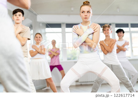 Group of teenagers learn to dance hip-hop and other modern dances in spacious dance studio 122617714