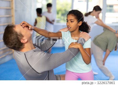 Black teenage girl attacking eyes of instructor during sparring at self-defense training Black teenage girl attacking eyes of instructor during sparring at self-defense training 122617861