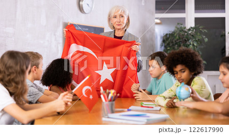 Female teacher showing turkish flag to kids in geography class 122617990