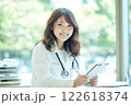 笑顔の女性医師が診察室でカルテを確認する様子 122618374