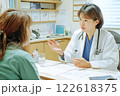 笑顔の女性医師が診察室でカルテを確認する様子 122618375