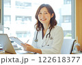 笑顔の女性医師が診察室でカルテを確認する様子 122618377