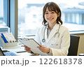 笑顔の女性医師が診察室でカルテを確認する様子 122618378