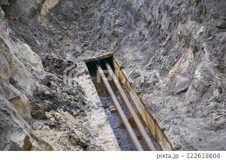 Dug hole with plastic metal water sewer pipes for repair Dug hole with plastic metal water sewer pipes for repair 122618608