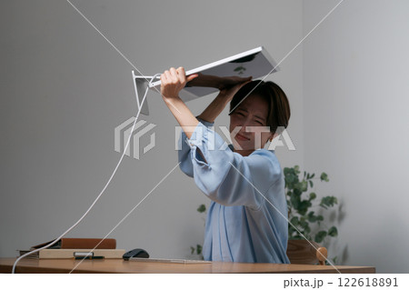 ストレスでパソコンを破壊する女性 122618891