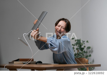 ストレスでパソコンを破壊する女性 122618892