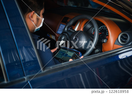 Checking a car engine OBD for repair at car garage Checking a car engine OBD for repair at car garage 122618958