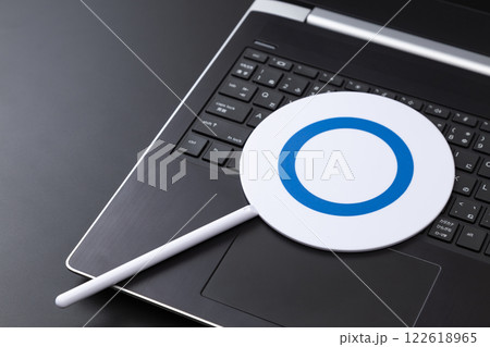 黒背景にノートパソコンとマルバツ札 黒背景にノートパソコンとマルバツ札 122618965