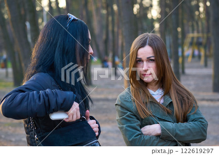 Two young women girlfriends have serious conversation discussion in city park Two young women girlfriends have serious conversation discussion in city park 122619297