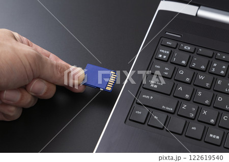 パソコンにSDカードを差し込む手元 パソコンにSDカードを差し込む手元 122619540