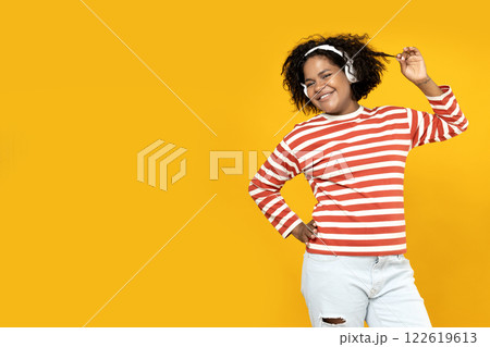 Young African American woman listening to music in headphones 122619613
