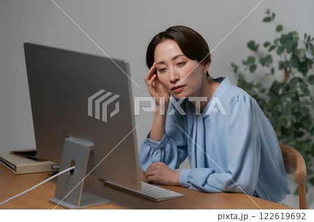 パソコンの画面を見て悩む女性 122619692