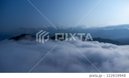 The mountain range with visible silhouettes seen through the colorful fog in the morning. 122619948