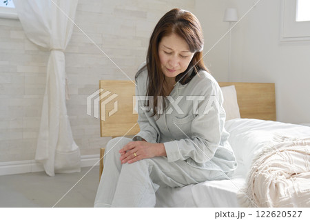 膝が痛いパジャマを着た中年の女性 膝が痛いパジャマを着た中年の女性 122620527