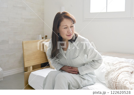 腹痛のパジャマを着た中年の女性 腹痛のパジャマを着た中年の女性 122620528