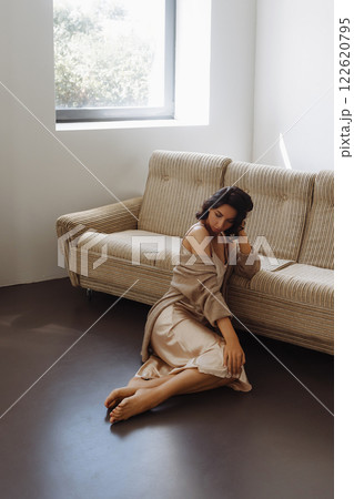 Young woman sitting on the sofa in the living room. Young woman sitting on the sofa in the living room. 122620795