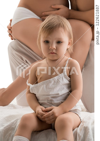 Baby sitting near kissing parents 122621887
