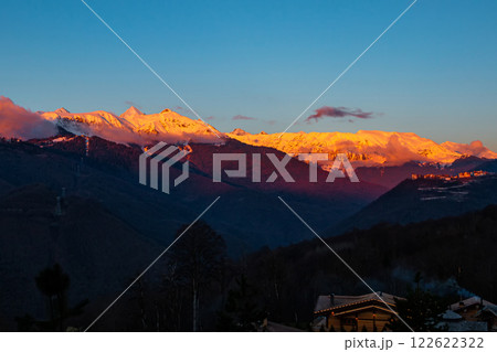 The last rays of sunlight cover the mountain peaks covered with snow. Picturesque evening in the mountains The last rays of sunlight cover the mountain peaks covered with snow. Picturesque evening in the mountains 122622322