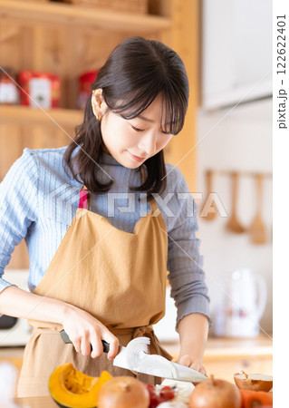キッチンで料理をする女性(野菜を切る) キッチンで料理をする女性(野菜を切る) 122622401