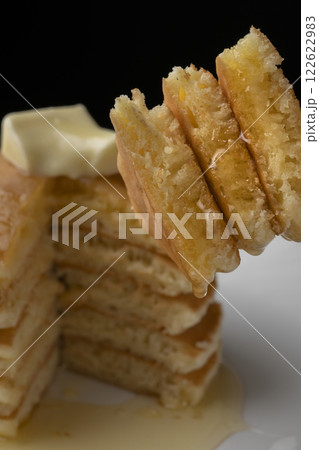 蜂蜜をかけたホットケーキをフォークで持ち上げる 122622983