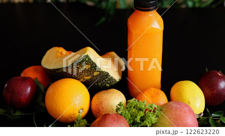 Fresh fruits including orange squash, yellow lemon, and red apple paired with vibrant juice bottle showcase organic nature benefits. Eco-friendly message highlights eco health values. 122623220
