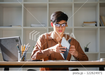 Young man studying online and researching financial concepts for education and career development 122624971