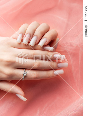 Woman showing stylish white nails and engagement ring on pink background 122625591