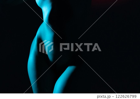 Woman with beautiful naked body studio portrait illuminated with blue light 122626799