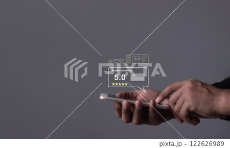 Young Man hand holding Smart Phone with five star to review and give 5 stars Young Man hand holding Smart Phone with five star to review and give 5 stars 122626989