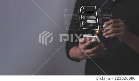Young man with smartphone mobile hand using a pen touching to sign a Online Business Contract Young man with smartphone mobile hand using a pen touching to sign a Online Business Contract 122626990