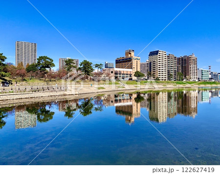 乙川の水面に映る秋晴れの青空と街並みの水鏡〈乙川の潜水橋より/愛知県岡崎市〉 乙川の水面に映る秋晴れの青空と街並みの水鏡〈乙川の潜水橋より/愛知県岡崎市〉 122627419