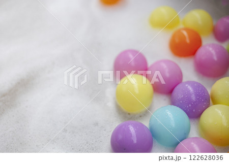 Many pastel colored plastic balls in swimming pool Many pastel colored plastic balls in swimming pool 122628036