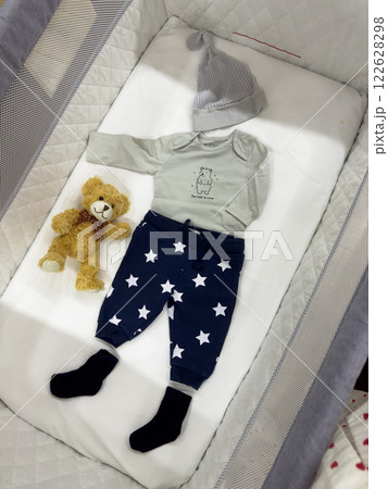 Baby Outfit with Teddy Bear in Crib 122628298