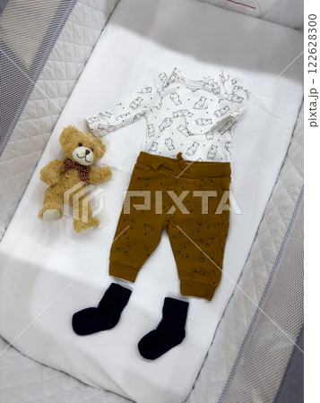 Baby Outfit with Teddy Bear in Crib Baby Outfit with Teddy Bear in Crib 122628300