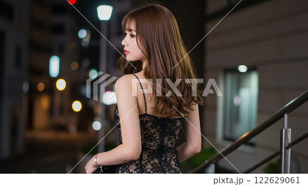 階段で佇む黒レースドレスの女性が魅せる洗練された姿	 122629061