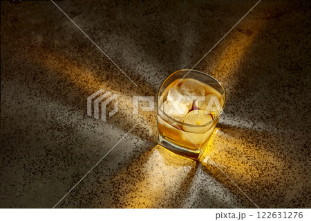 Whiskey in a crystal glass with ice on a old stone table. 122631276