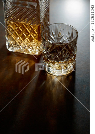 Decanter and cut glass tumbler with whiskey. Decanter and cut glass tumbler with whiskey. 122631342