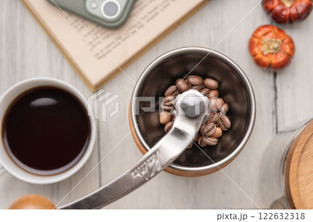 コーヒーを飲みながら珈琲豆を挽く コーヒーを飲みながら珈琲豆を挽く 122632318