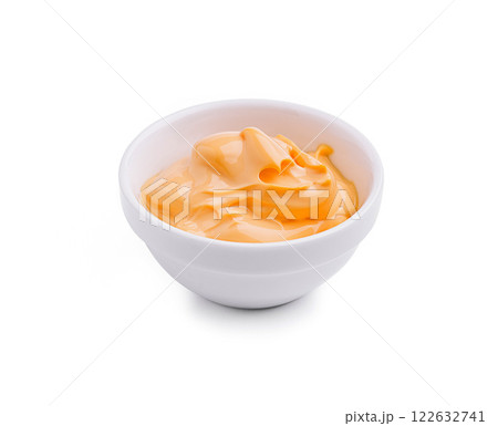 Creamy orange dip served in a white bowl perfect for snacks and appetizers at gatherings or parties 122632741