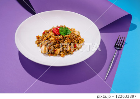 Colorful couscous salad with vegetables and chicken served on a vibrant background Colorful couscous salad with vegetables and chicken served on a vibrant background 122632897