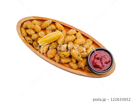 Crispy golden fried seafood served with a lemon wedge and tangy dipping sauce in a wooden platter Crispy golden fried seafood served with a lemon wedge and tangy dipping sauce in a wooden platter 122633052