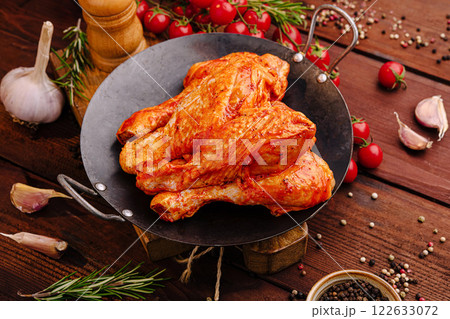 Deliciously seasoned chicken cooked with fresh herbs and spices on a rustic wooden table Deliciously seasoned chicken cooked with fresh herbs and spices on a rustic wooden table 122633072
