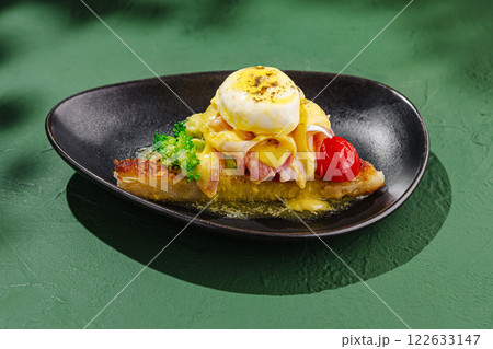 Delicious poached eggs with hollandaise sauce served on toasted bread with broccolini and cherry tomatoes in a cozy restaurant setting Delicious poached eggs with hollandaise sauce served on toasted bread with broccolini and cherry tomatoes in a cozy restaurant setting 122633147