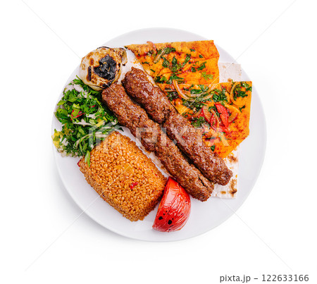 Savory kebabs served with rice and flatbread on a white plate for lunch Savory kebabs served with rice and flatbread on a white plate for lunch 122633166