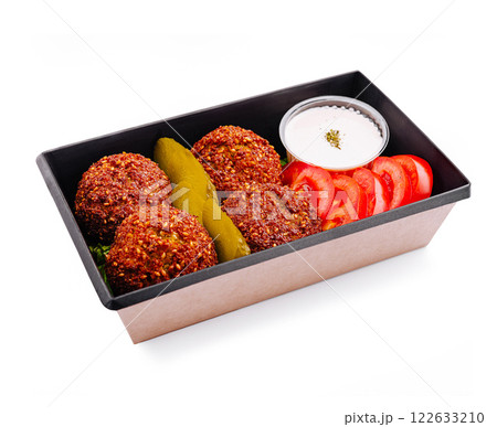 Delicious falafel platter served with fresh vegetables and dipping sauce for a healthy meal 122633210