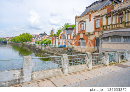 The striking Art Nouveau building of the Hucak hydroelectric power station stands proudly along the river in Hradec Kralove, showcasing its intricate design and historical significance in the region. 122633272