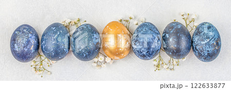 Banner. Easter eggs with blossoms spring flowers. Stylish golden and blue eggs. on a white background. Flat lay. Copy space 122633877
