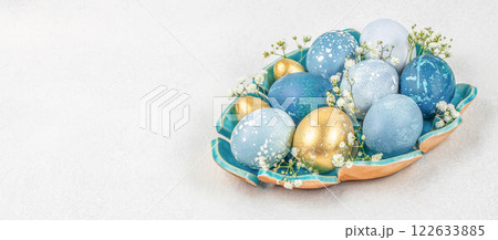 Easter eggs with spring flowers on a blue plate. Happy Easter card. Long banner format. top view. copy space Easter eggs with spring flowers on a blue plate. Happy Easter card. Long banner format. top view. copy space 122633885