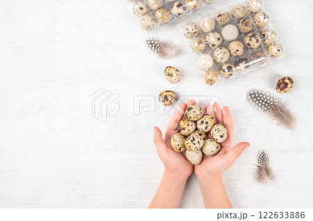 Quail eggs in hands. Containers of quail eggs on a light background, ecological farm products. top view. copy space 122633886